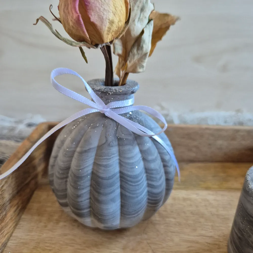 Vase klein und bauchig, mit seitlichen Rillen, für einen kleine Trockenblumenstrauß, aus grauem Gießbeton, marmoriert und...